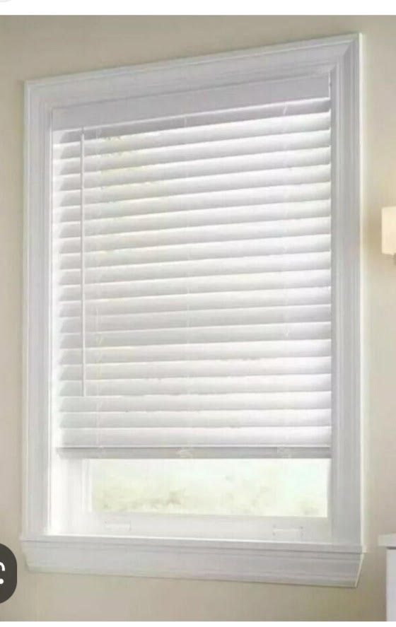 Close-up of two-inch white faux wood blinds in a white window frame