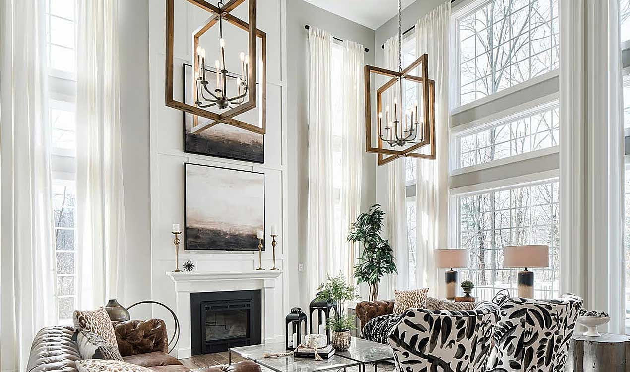 Sheer white floor-to-ceiling drapes on two-story living room windows