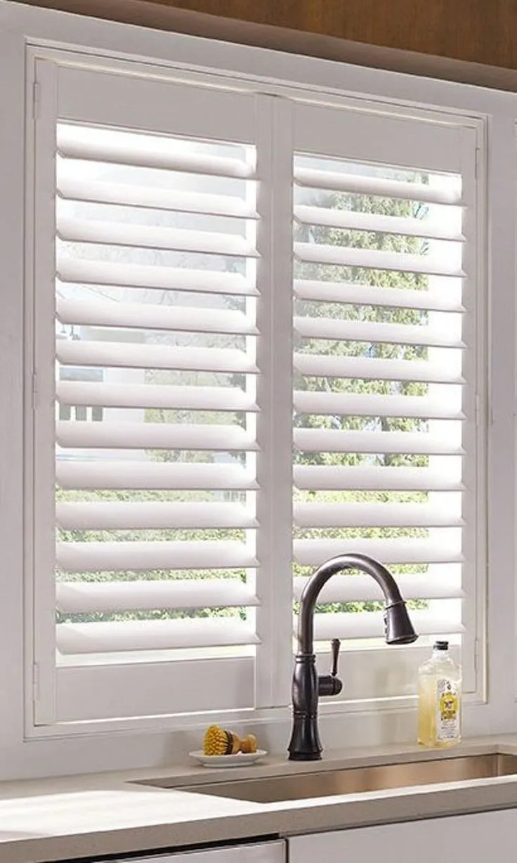 White plantation shutters above a kitchen sink